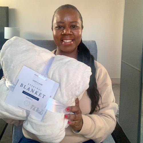 Smiling female holding everyday blanket