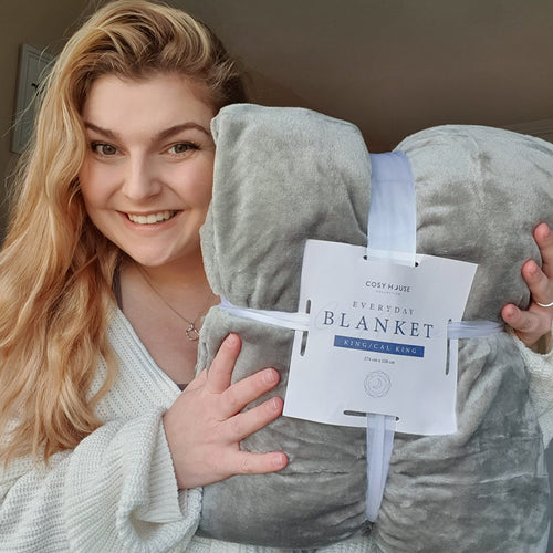 Smiling female holding everyday blanket