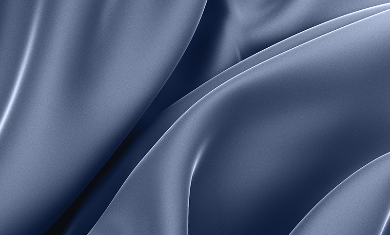 Close-up of smooth, flowing blue fabric with gentle folds and soft highlights, creating an abstract, silky texture.