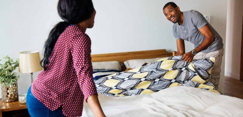 Couple making the bed together